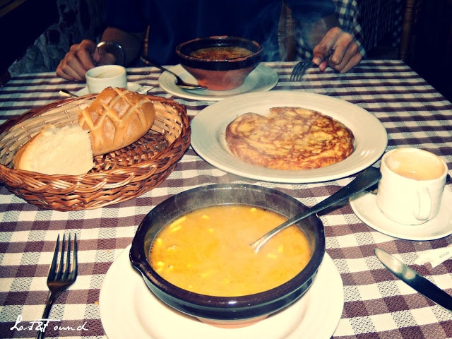 A table topped with plates of food on a plate, with Soup