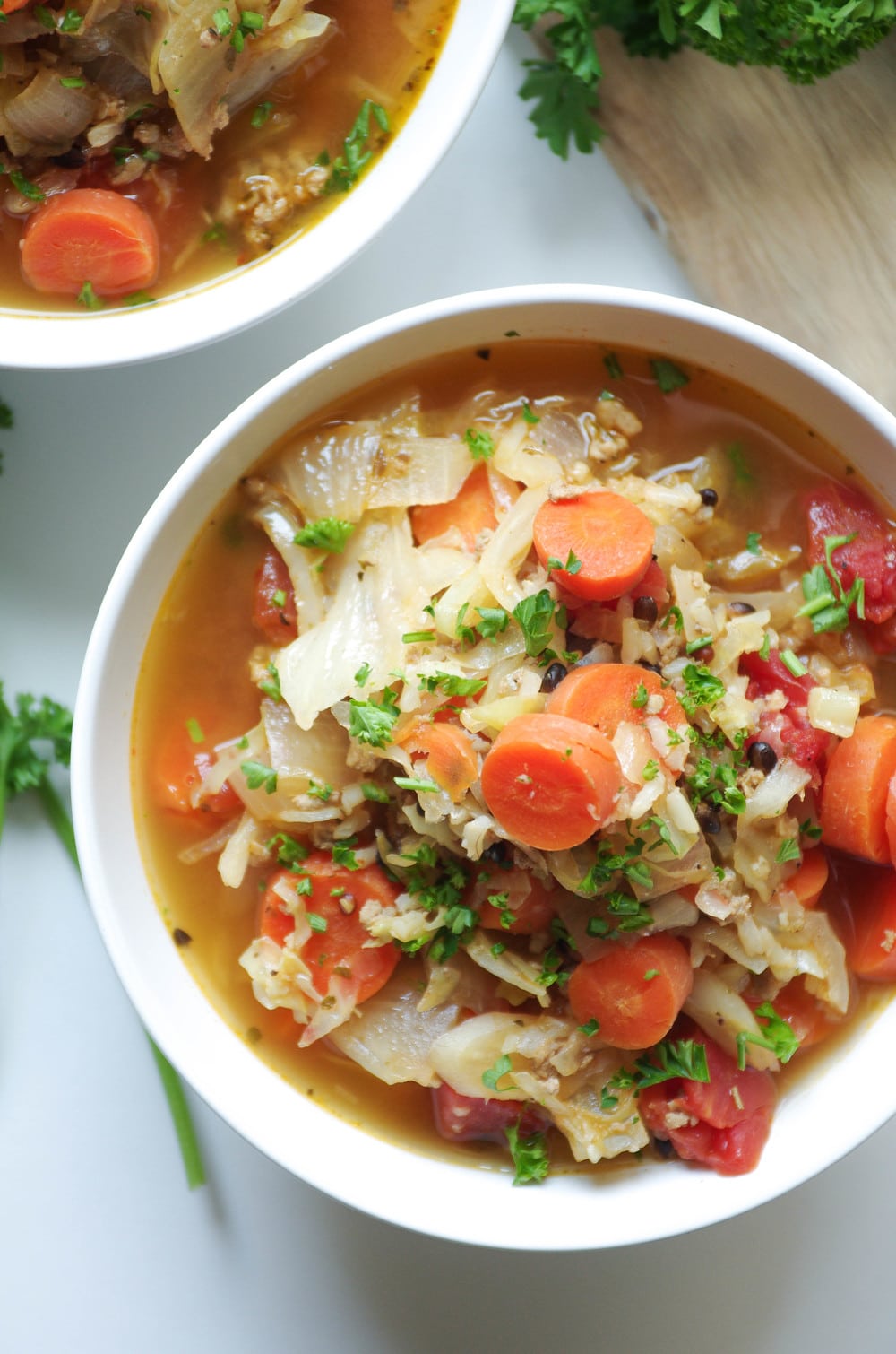 Russian Cabbage Soup with carrots and turkey in white bowl with parsley