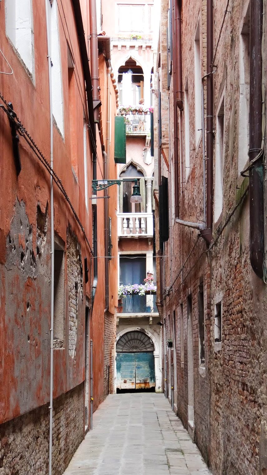 A narrow street in front of a brick building