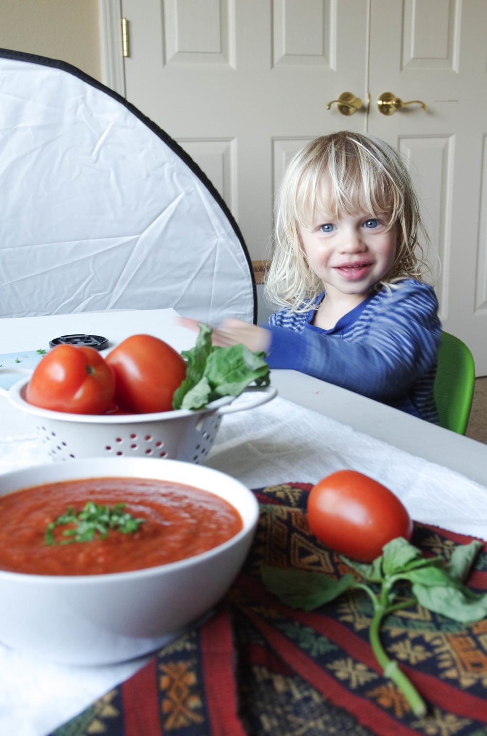 Three year old boy helping with tomato basil soup photoshoot.