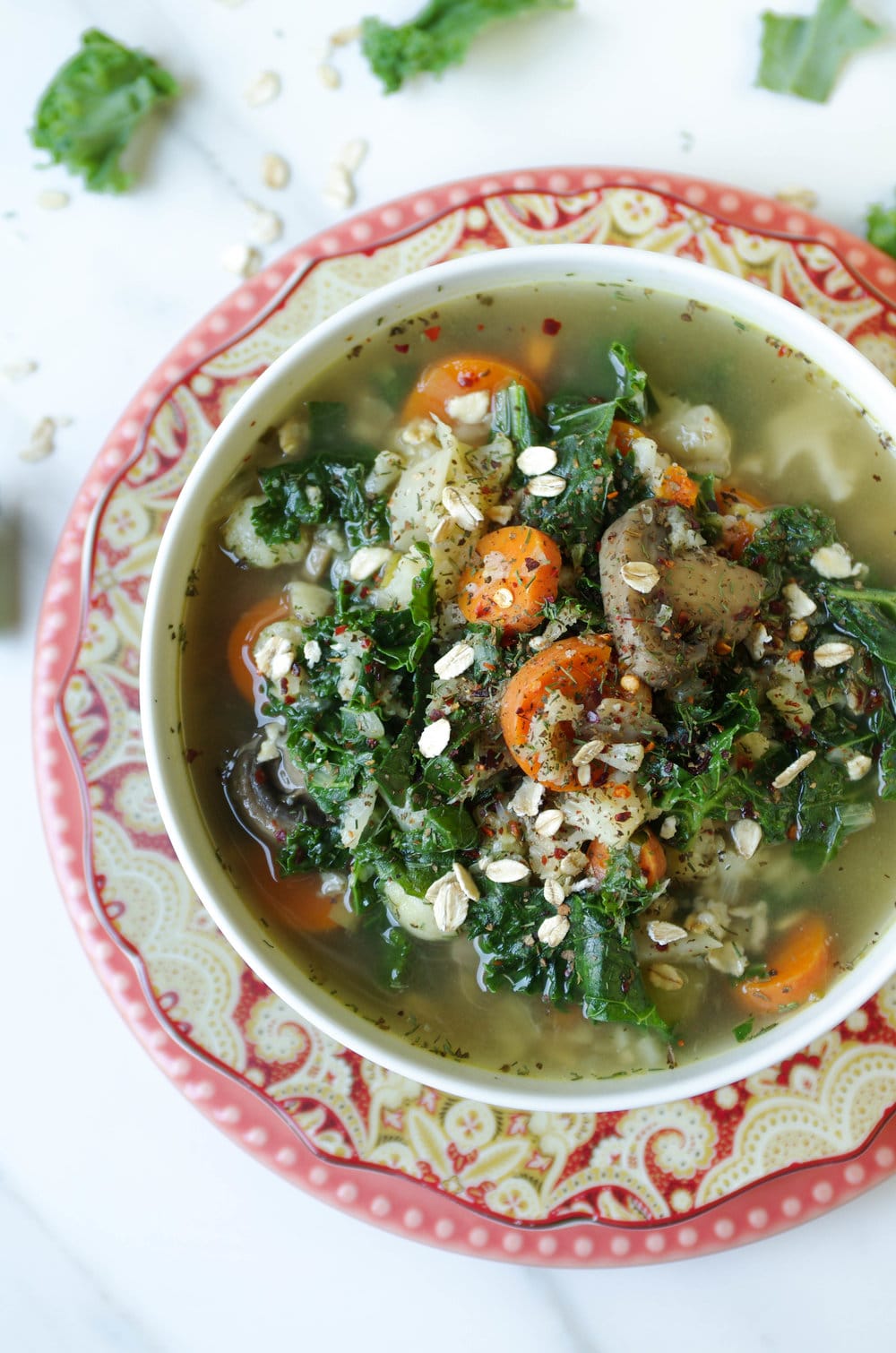 white bowl on red plate full of vegan Vegetable Soup