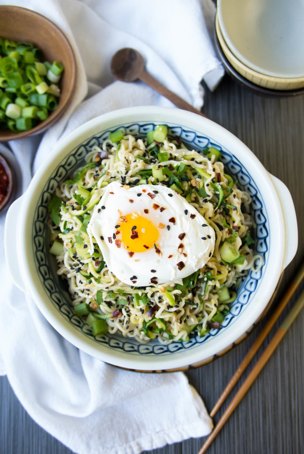 bowl of Ginger Garlic Miso Ramen Noodles with Poached Egg sprinkled with pepper and dried peppers