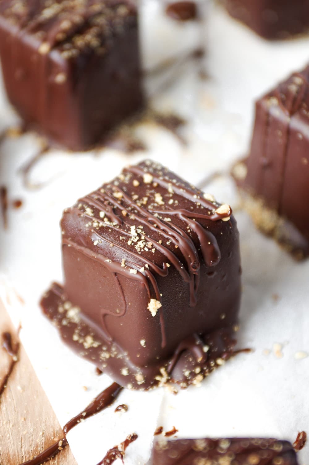 A close image up of a single bite-size cheesecake bite covered in a sweet chocolate shell coating.