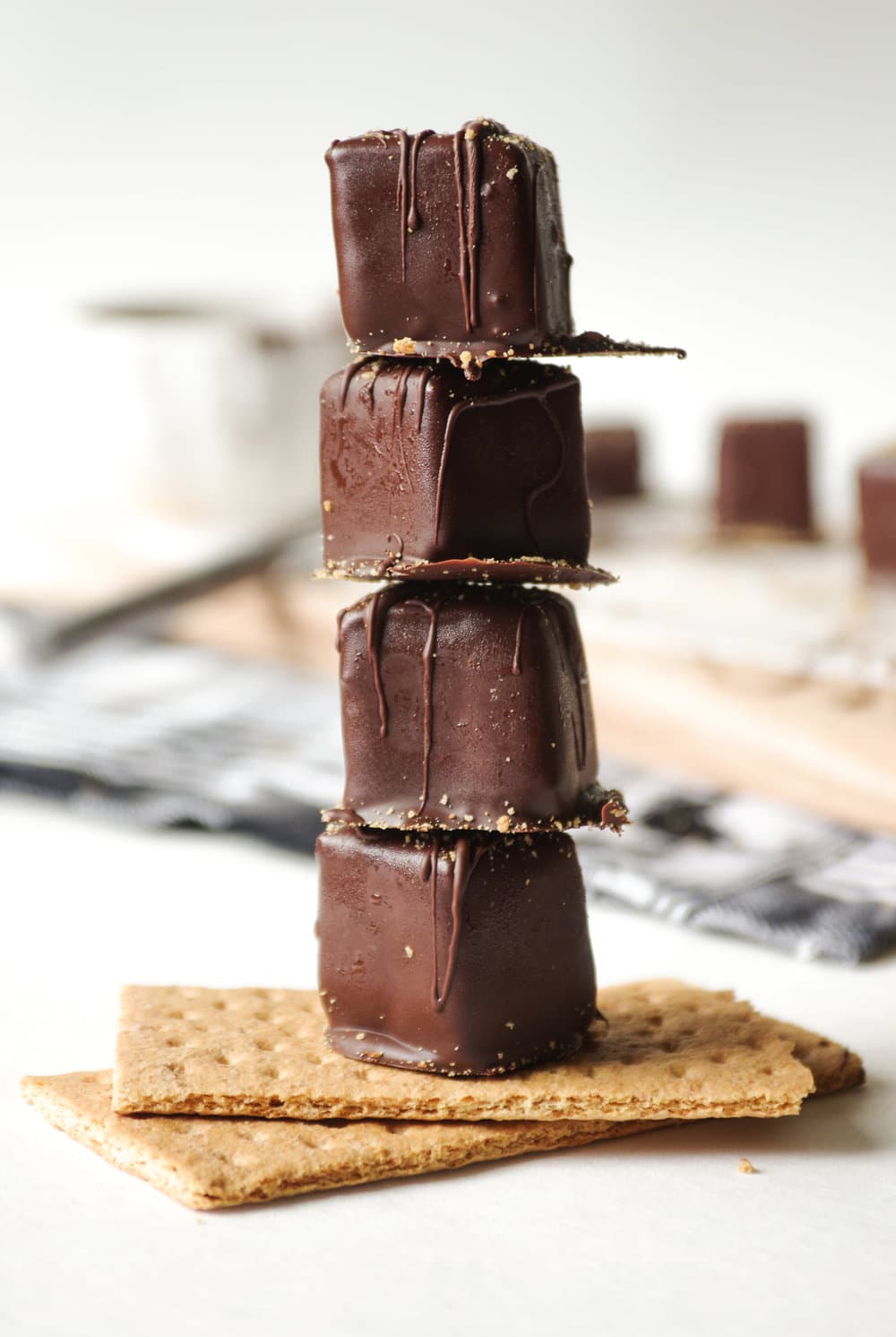 Four Chocolate Covered Cheesecake Bites stacked on 2 gram crackers