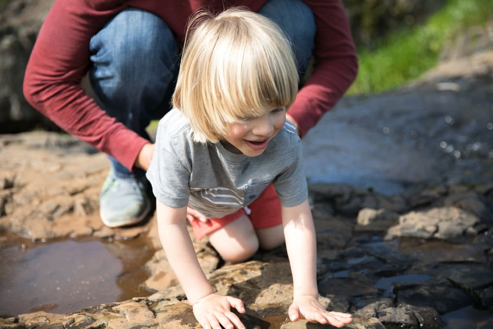 A small child sitting on a rock