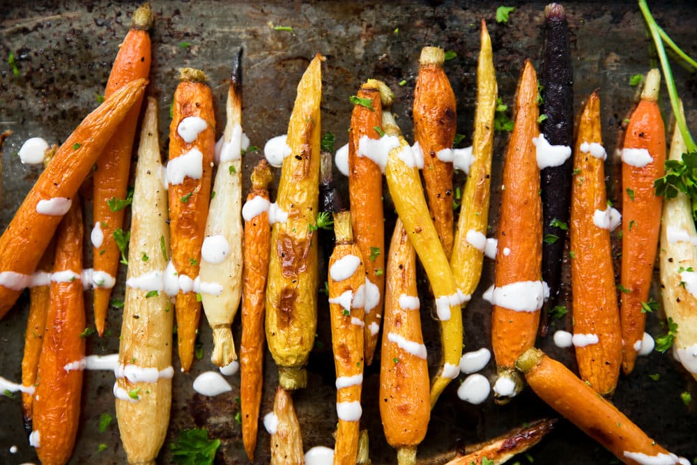 Roasted Carrots on a sheet pan drizzled with Lemon Tahini Sauce